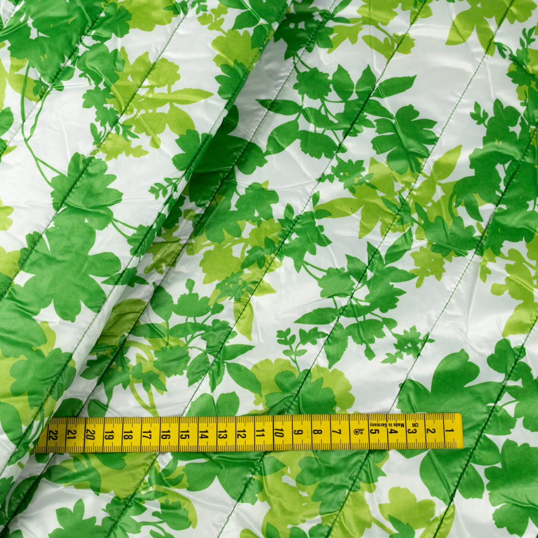 Tkanina pikowaną z ociepliną wzór liście na kremowym tle