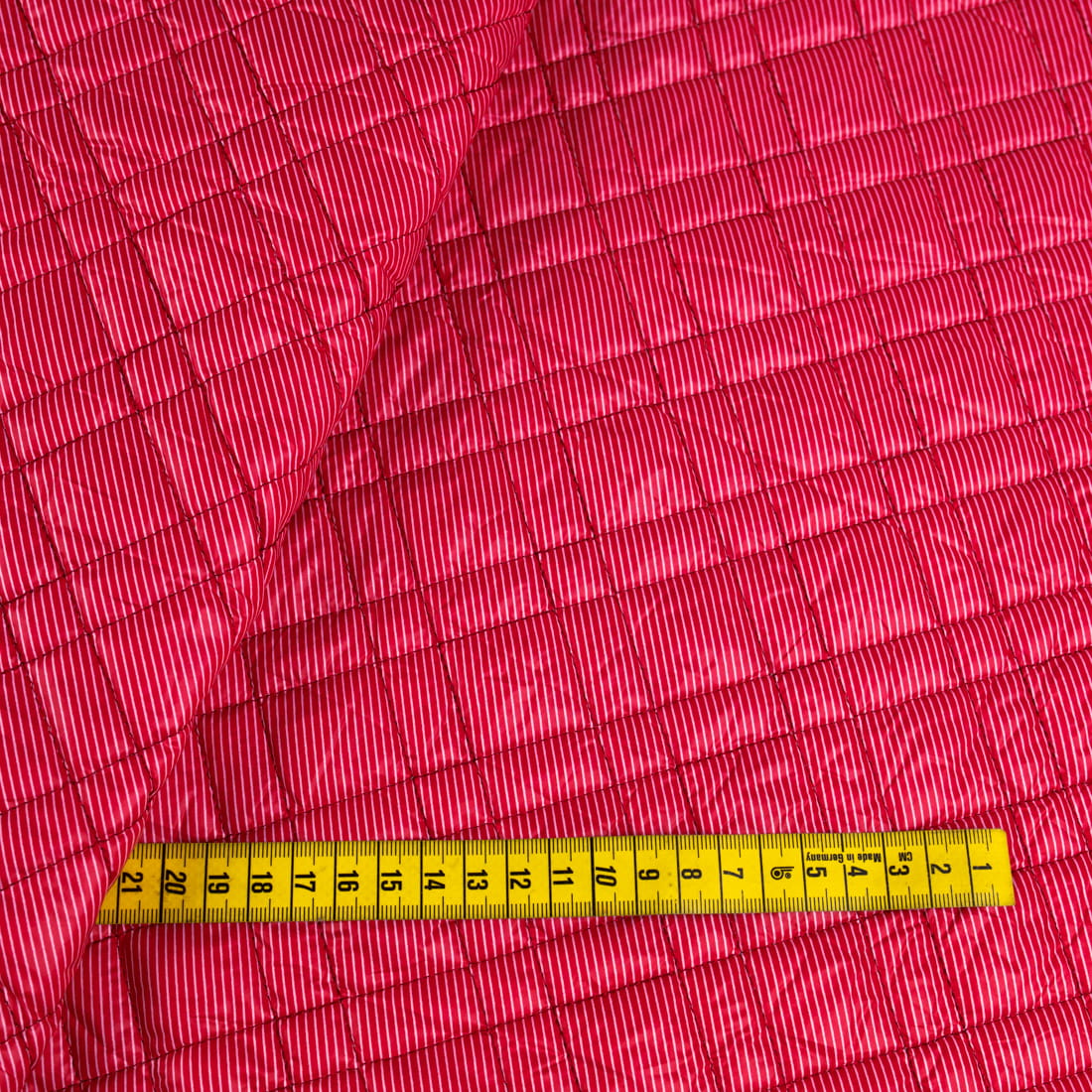 Tkanina pikowaną z ociepliną wzór paski na malinowym tle